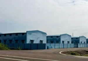 Row of blue industrial buildings along a road